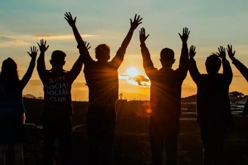 Silhouettes of people gathered to watch sunset.